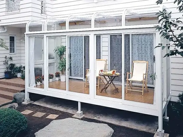 Glass sunroom creating a protected garden seating space