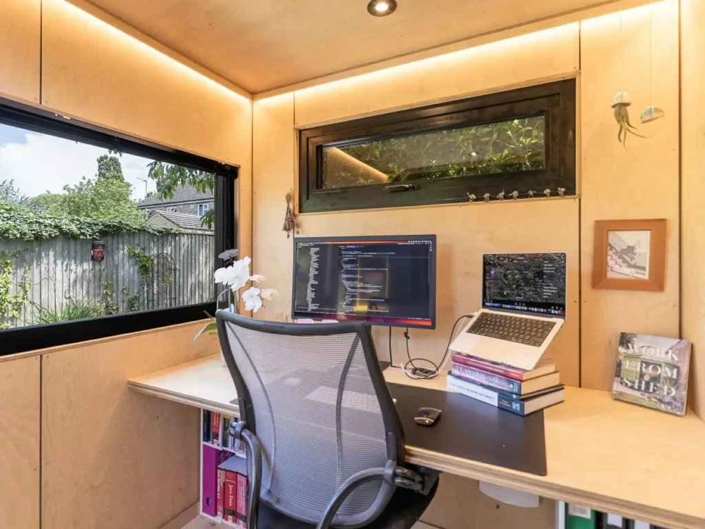 Comfortable outdoor office pod interior with ergonomic desk setup and modern workspace design